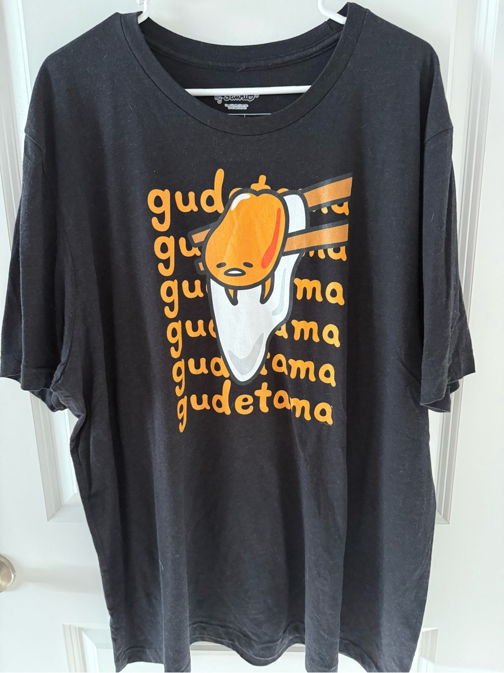 Sanrio Black Gudetama Short Sleeve Graphic Tee with Orange and White Print